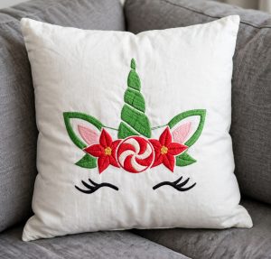 Christmas Unicorn Face Machine Embroidery Design embroidered on a pillow